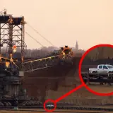 Gigantyczna koparka, największa koparka na świecie, w kopalni odkrywkowej. W powiększeniu widać mały biały pickup.