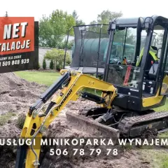 Żółta minikoparka Yanmar na placu budowy. Usługi minikoparką wynajem, zapytaj o cenę za godzinę.