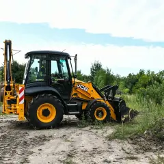 Żółta koparko-ładowarka JCB na placu budowy. Zastanawiasz się, ile kosztuje kurs na koparko-ładowarkę?