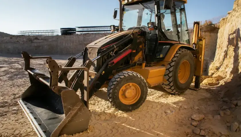 Żółta koparko-ładowarka JCB na budowie. Pytanie: jaki olej hydrauliczny do koparki jcb?
