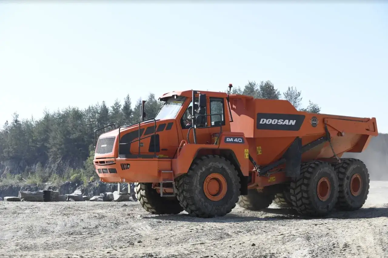 Pomarańczowy wozidło przegubowe Doosan DA 40 na placu budowy. Serwis Doosan Poznań dba o sprzęt.