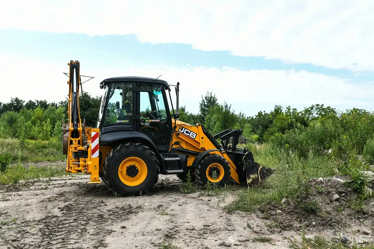 Żółta koparko-ładowarka JCB na placu budowy, gotowa do pracy. Idealne miejsce na operator koparki kurs.