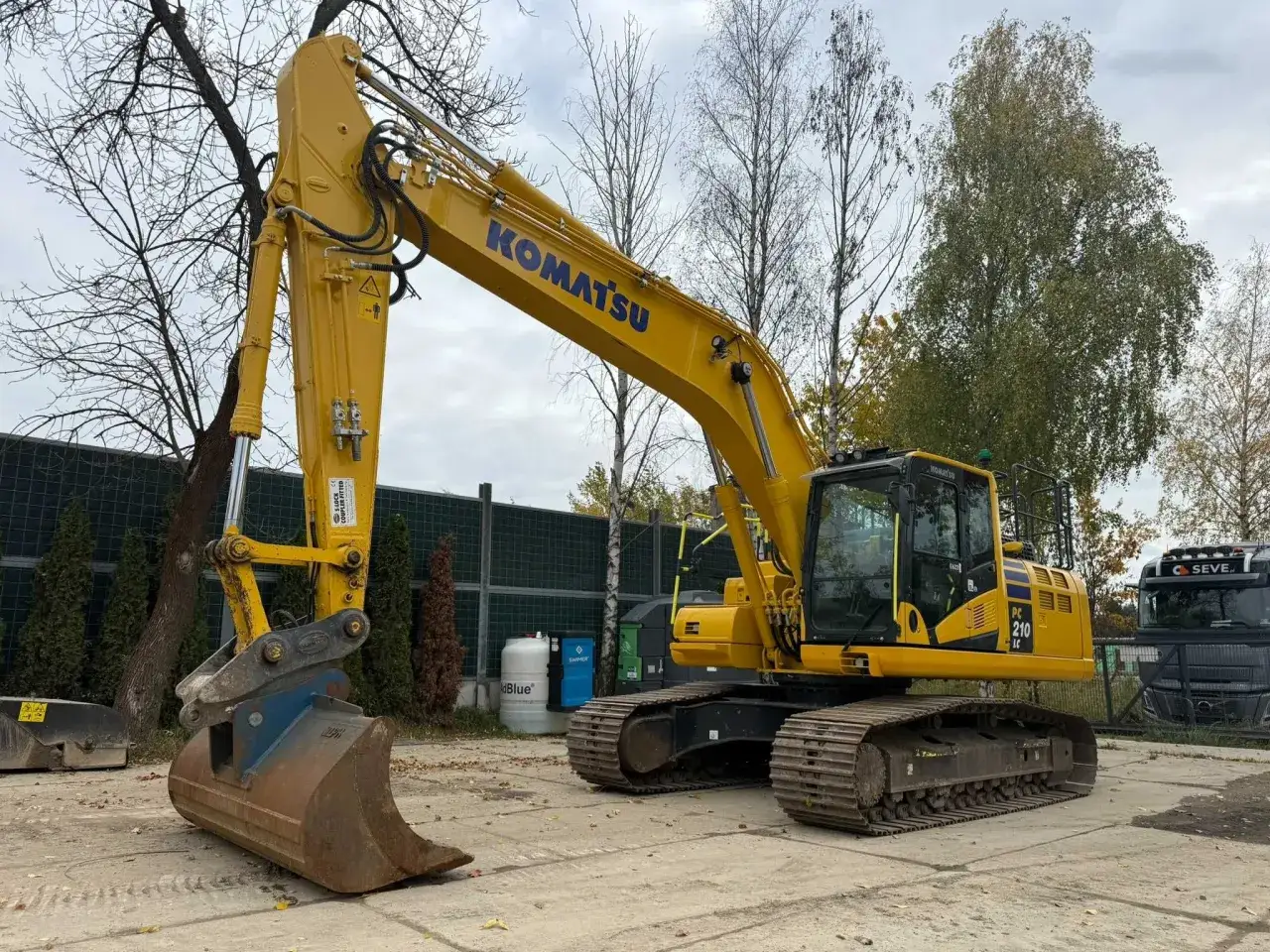 Żółta koparka gąsienicowa Komatsu PC 210 LC. Zastanawiasz się, ile kosztuje godzina pracy koparki gąsienicowej?